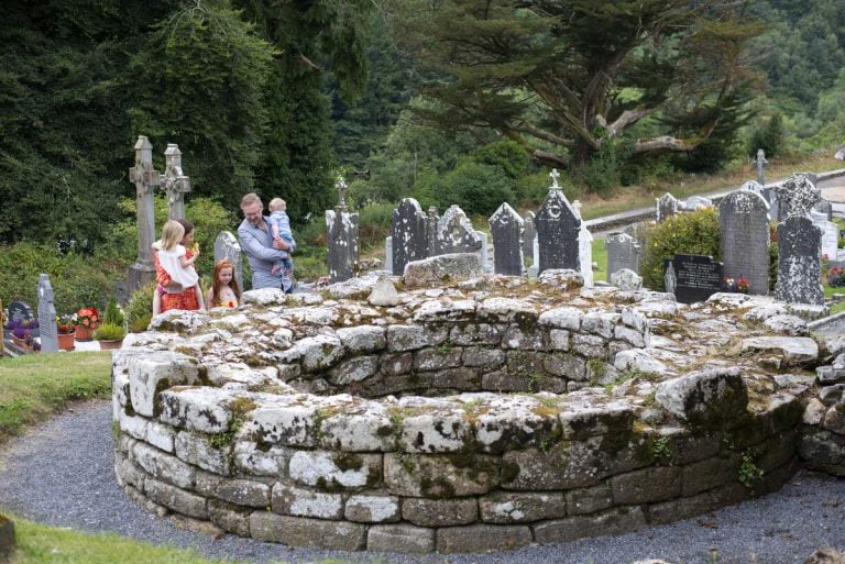 A family visits the 10th century round tower at St Mullins ecclesiastical site, St. Mullins, Co. Carlow